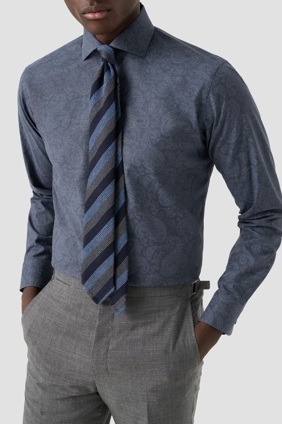 Chemise ajustée à imprimé cachemire, élégante avec motif paisley, portée avec cravate rayée et pantalon gris pour un style formel distingué.