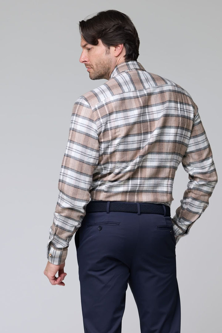 Homme portant une chemise à carreaux chevrons beige et gris en flanelle avec un pantalon bleu marine, vue de dos.