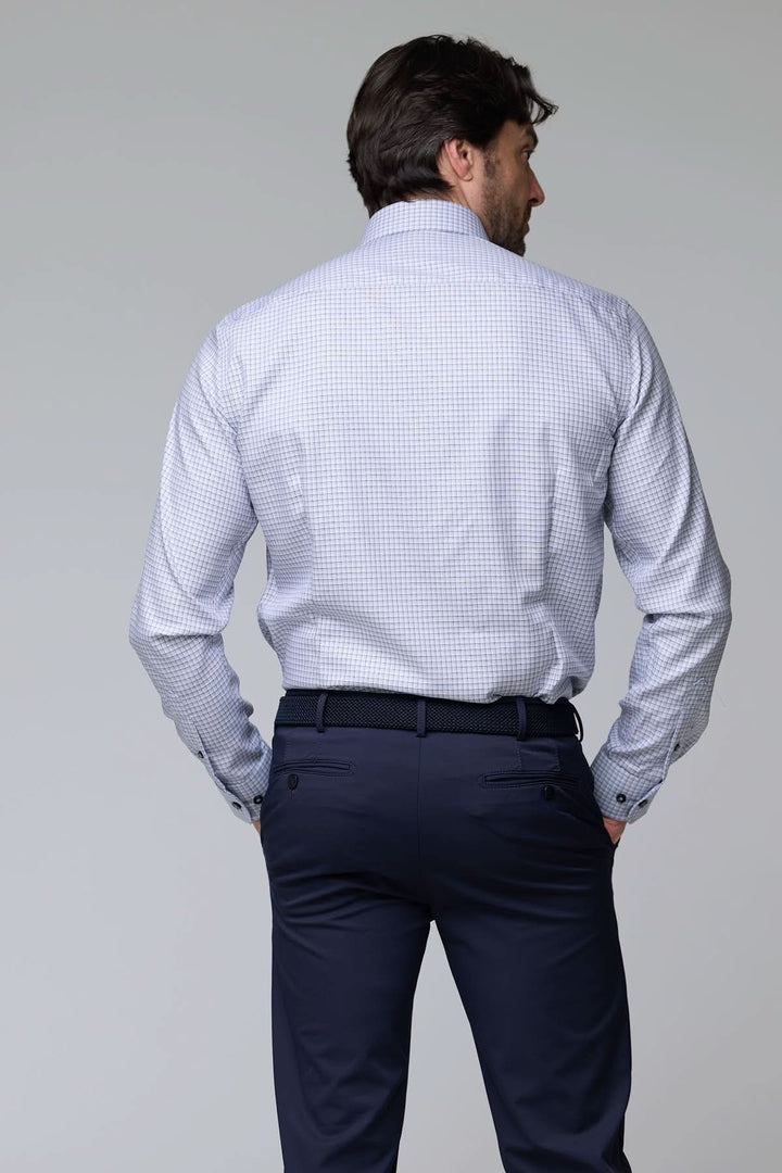 Homme portant une chemise à carreaux fins à manches longues, vue de dos, style contemporain.