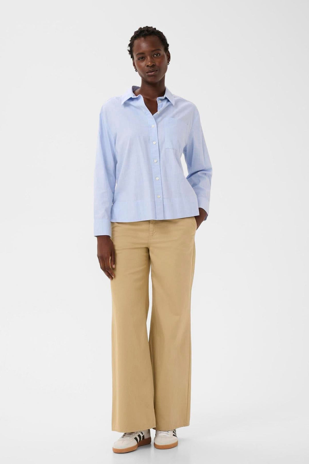 Femme portant une chemise classique en popeline Nenee à la coupe droite, col rigide et manches longues, idéale pour le bureau.