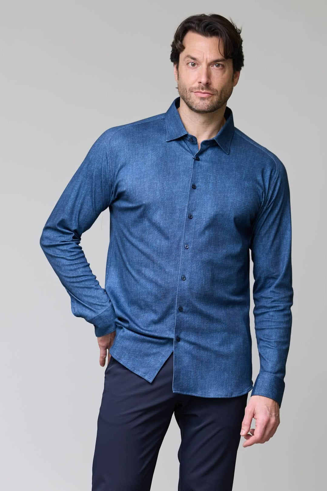 Homme portant une chemise en jersey extensible à manches longues, coupe ajustée et col classique, parfaite pour le travail et les loisirs.