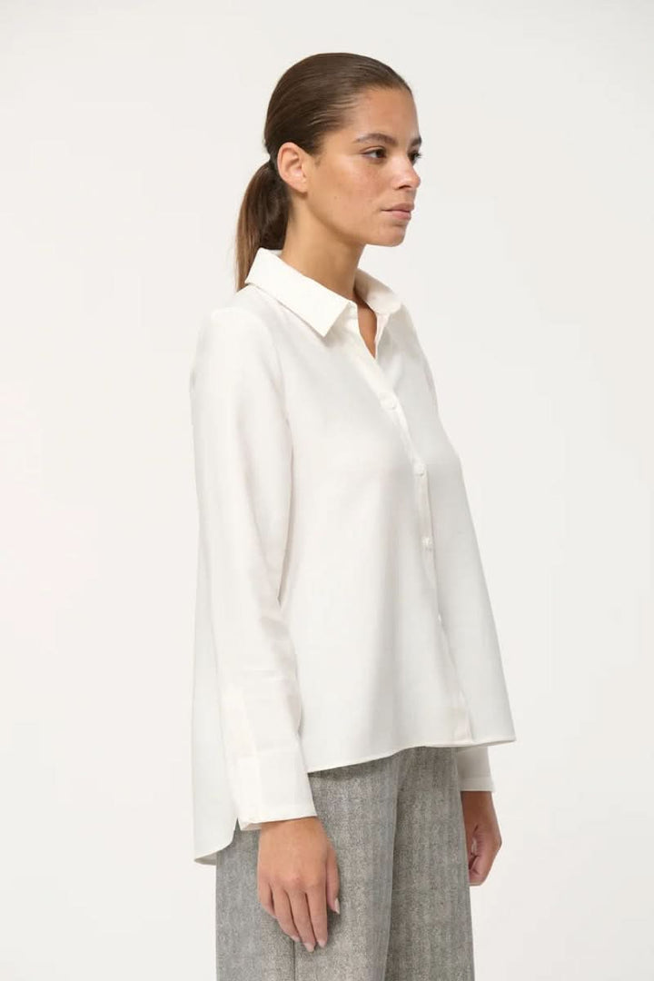 Chemise fluide élégante, coupe ample, col classique, tenue minimaliste chic pour le bureau et le quotidien.