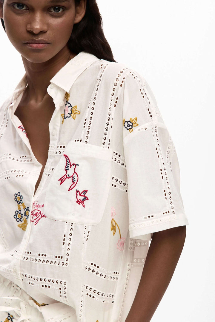 Chemise fluide brodée à manches courtes avec broderies délicates, idéale pour un look élégant et décontracté.