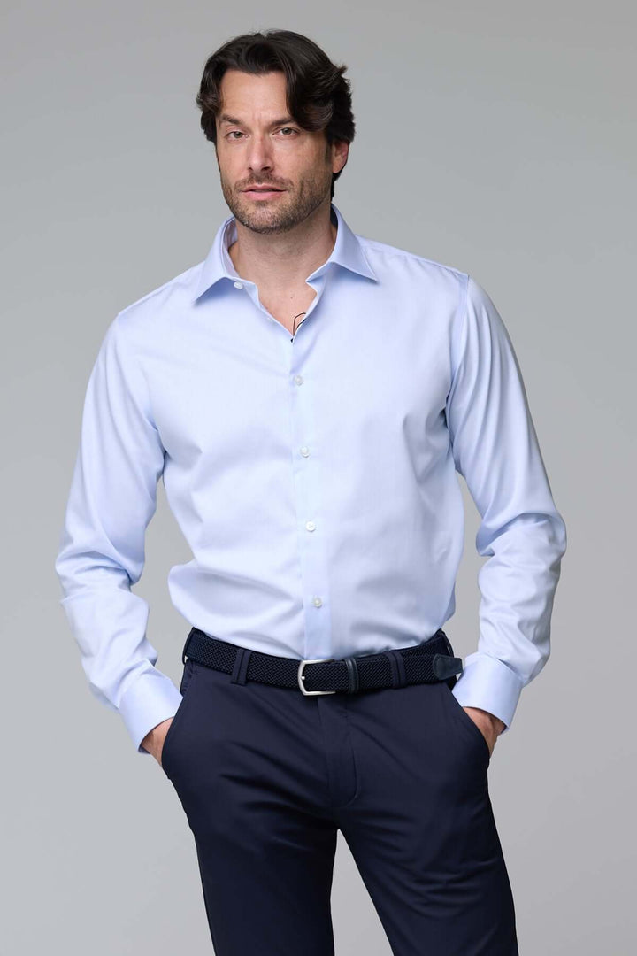 Homme portant une chemise infroissable de base satinée, manches longues, idéale pour occasions habillées, avec coupe ajustée élégante.