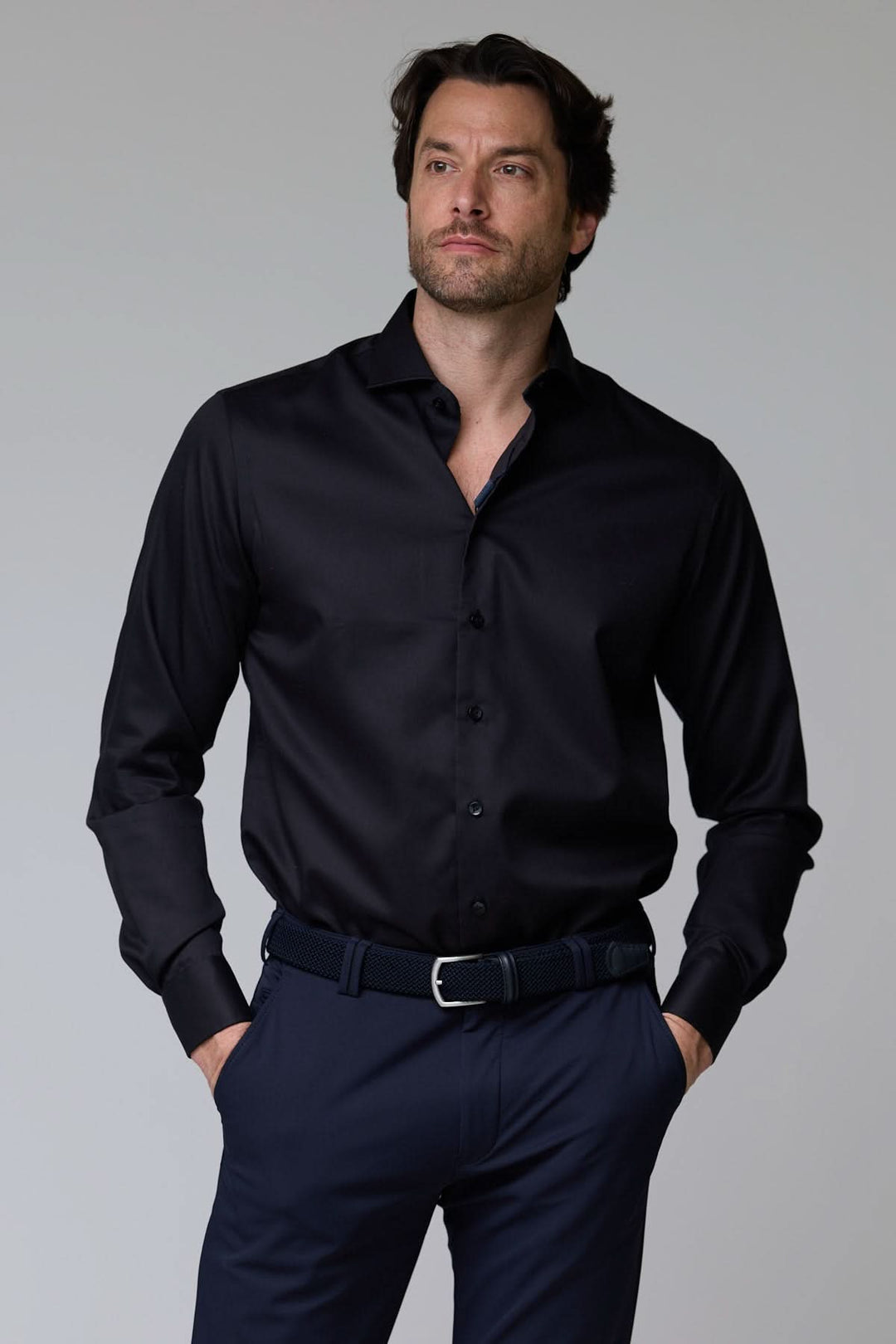Homme portant une chemise infroissable de base noire, élégante et au fini satiné, idéale pour un look professionnel sophistiqué.