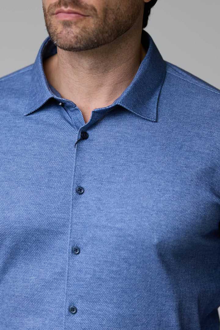 Homme portant une chemise jersey texturé bleue avec col structuré et manches longues
