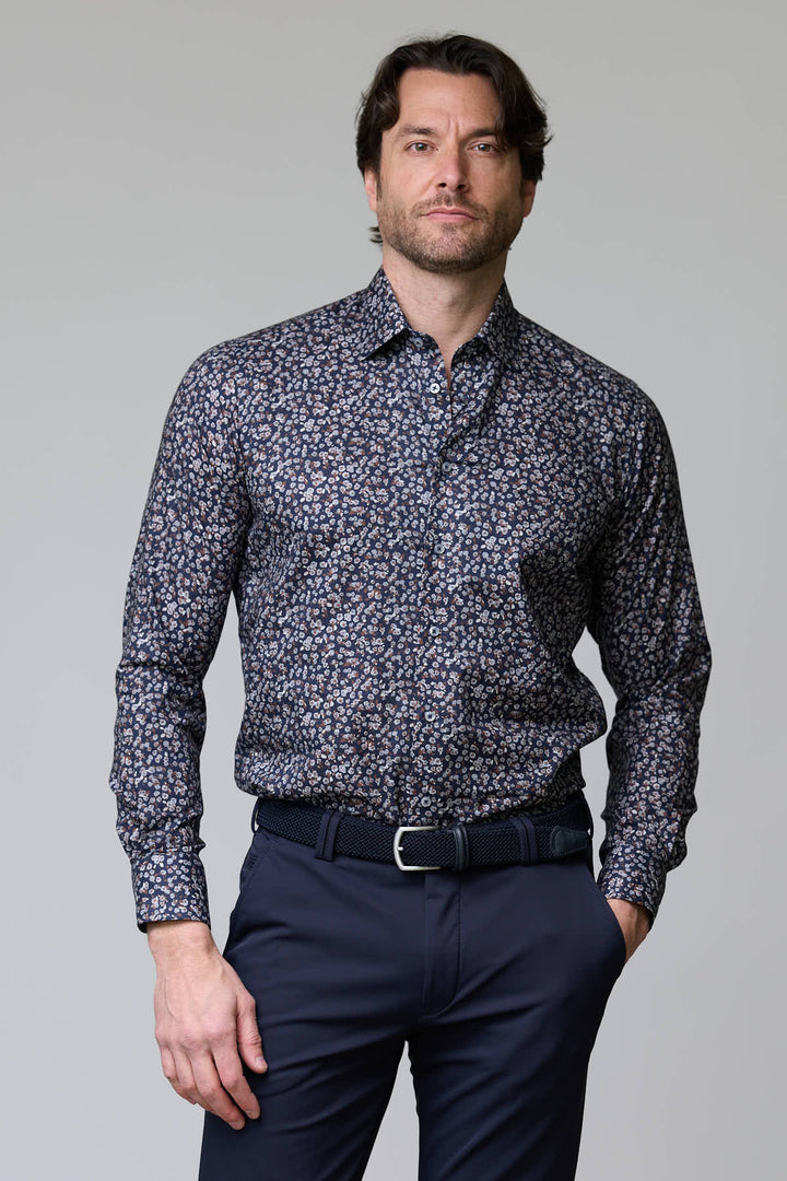 Homme portant une chemise à motif floral abstrait élégante et moderne, parfaite pour une tenue de soirée ou habillée.
