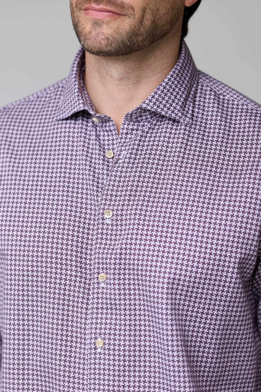 Homme portant une chemise à motif géométrique avec coupe ajustée et col classique semi-rigide.