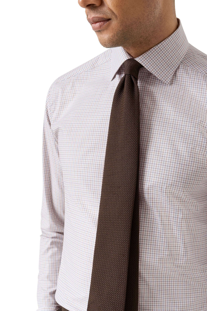 Homme portant une chemise motif micro-carreaux ajustée, parfaite pour le bureau et les sorties élégantes, avec une cravate marron.
