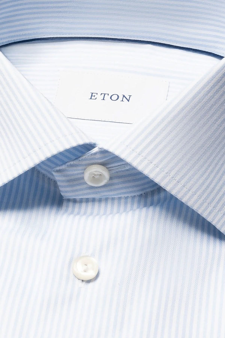 Chemise rayée en coton et lyocell avec col italien et boutons blancs, élégante pour un style raffiné et moderne.