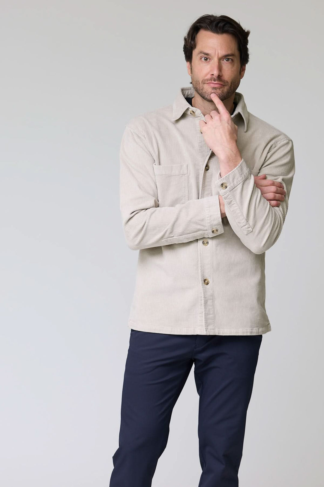 Homme portant une chemise sport en velours côtelé style surchemise avec col classique et poches plaquées, look décontracté et sophistiqué.