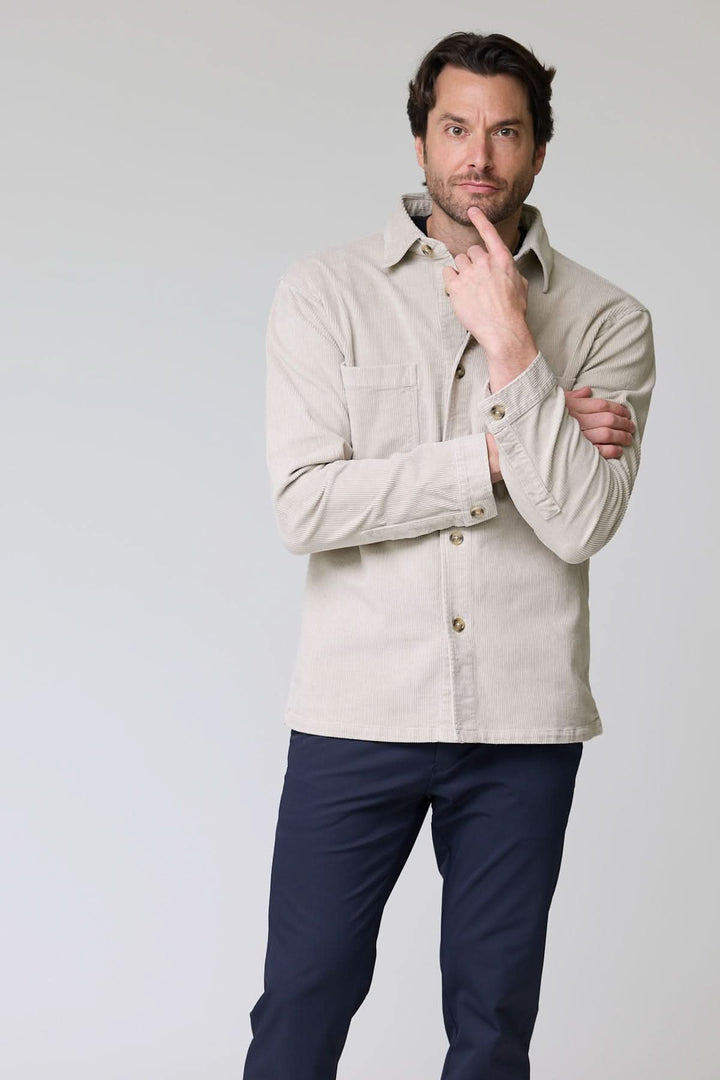 Homme portant une chemise sport en velours côtelé style surchemise avec col classique et poches plaquées, look décontracté et sophistiqué.