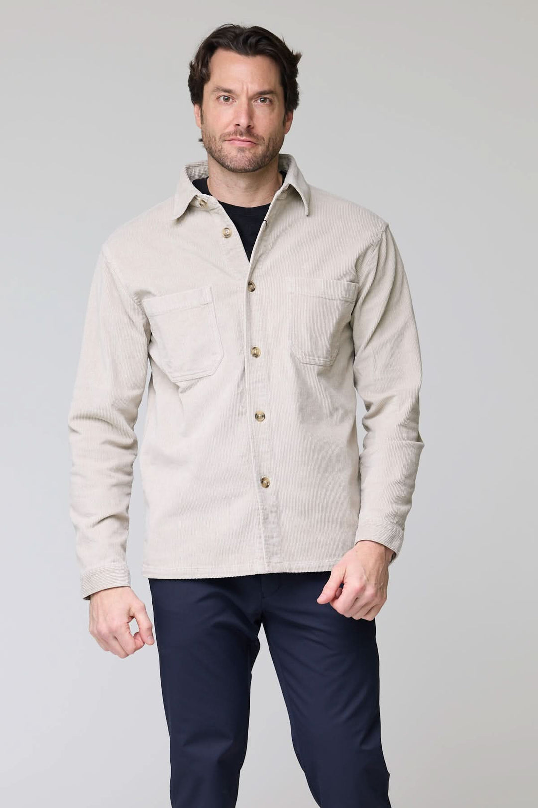 Chemise sport en velours côtelé style surchemise portée par un homme, avec poches plaquées et col structuré.