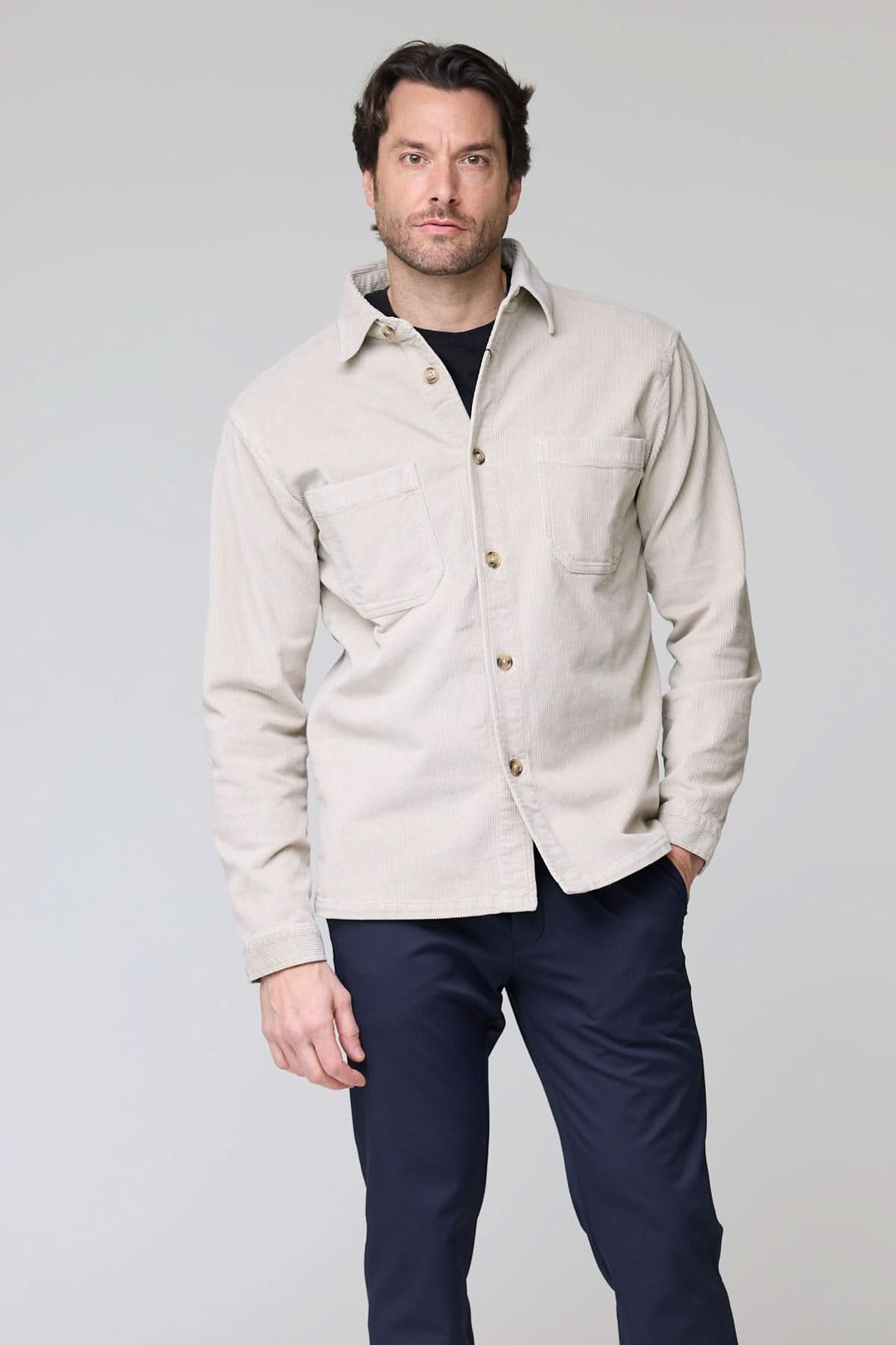 Homme portant une chemise sport en velours côtelé style surchemise avec poches plaquées et boutons contrastants.
