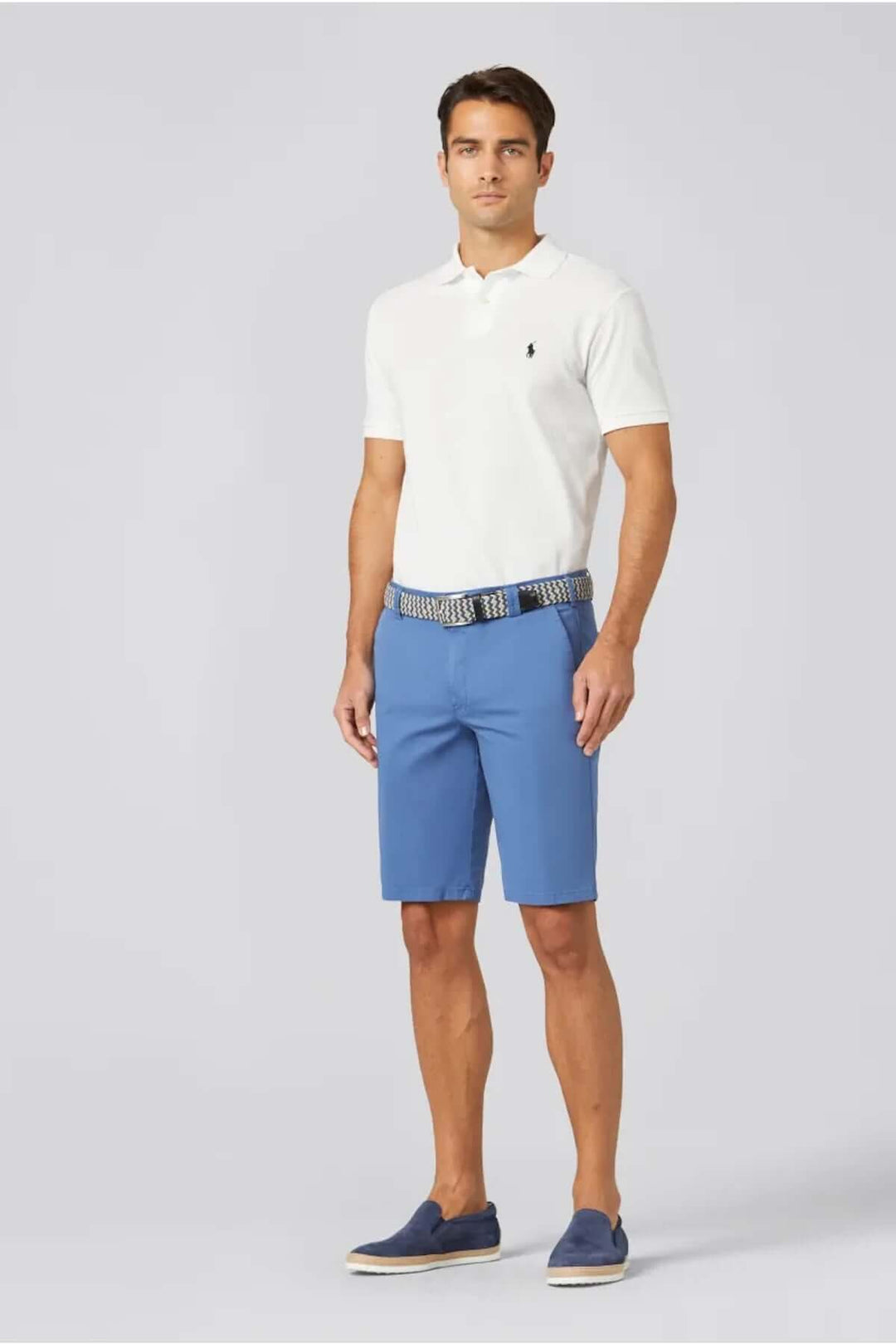 Homme portant un polo blanc et un short chino bleu, idéal pour un look estival décontracté.
