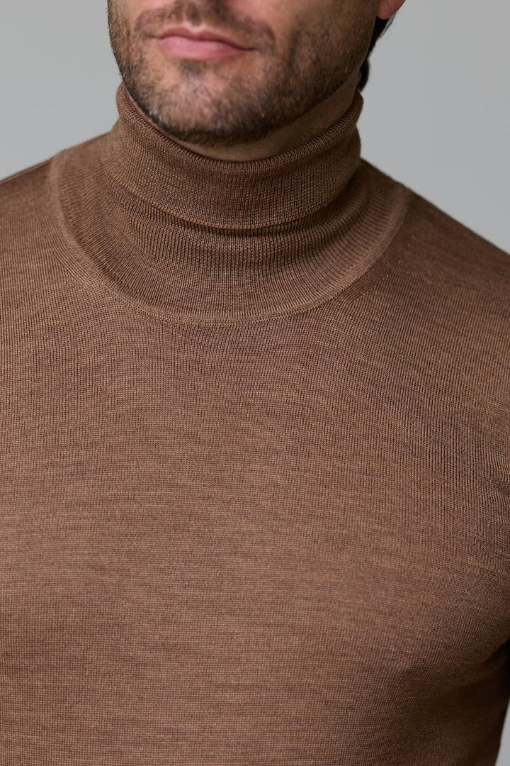 Homme portant un col roulé en laine mérinos marron, coupe ajustée, maille fine et élégante.