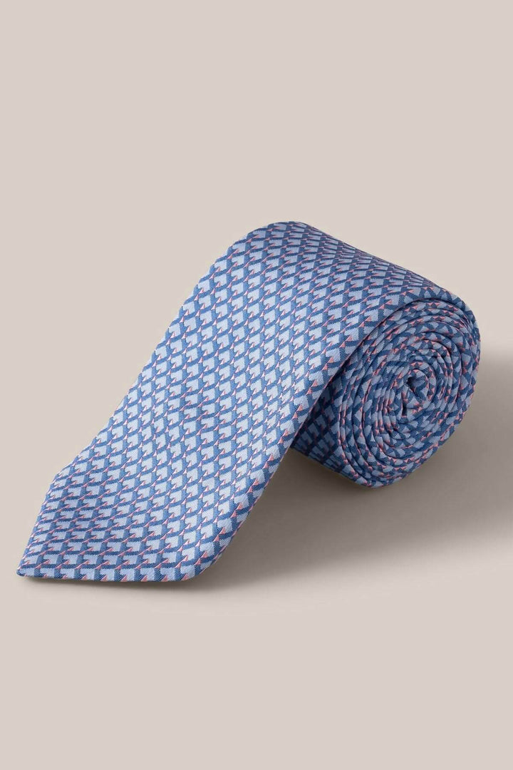 Cravate en soie à motif géométrique en nuances de bleu, gris et rose pâle, tissée par la maison Eton.
