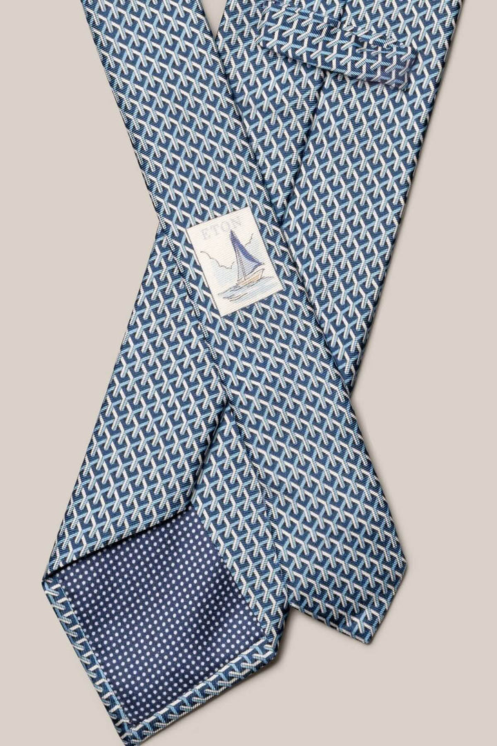 Cravate en soie bleu marine et blanc avec motif géométrique moderne, ajout de texture raffinée.
