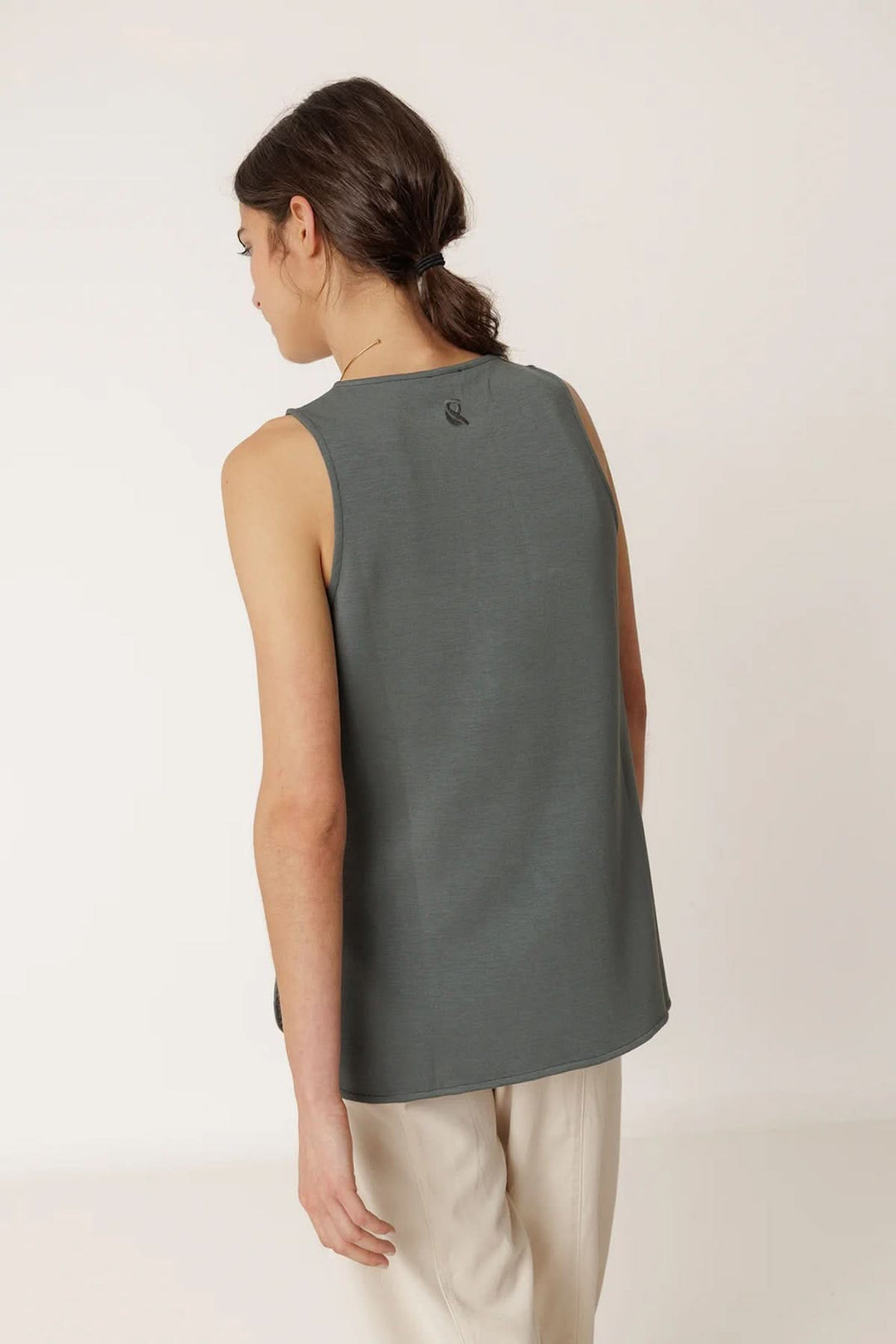 Femme portant un débardeur minimaliste à coupe fluide, vue arrière, style moderne et confortable, couleur gris anthracite.