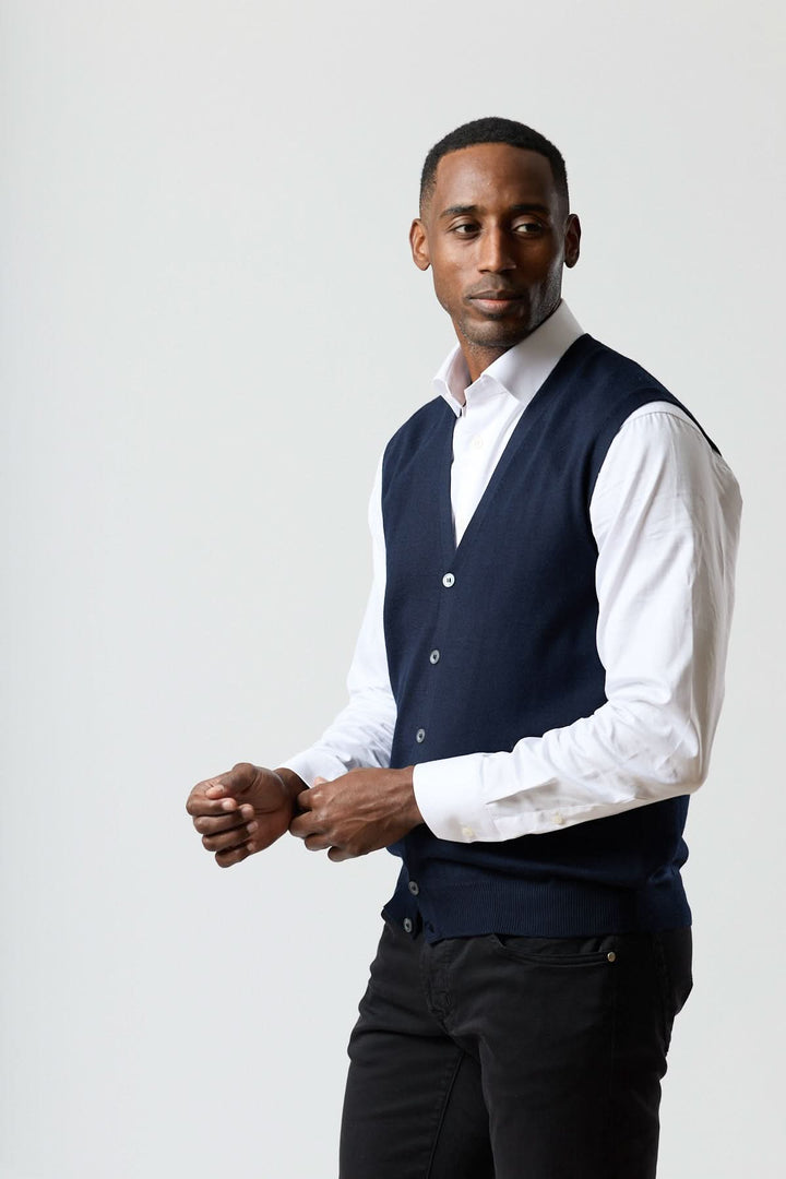 Homme portant un Gilet en laine mérinos à col en V, élégant et stylé, parfait pour une tenue raffinée et moderne.
