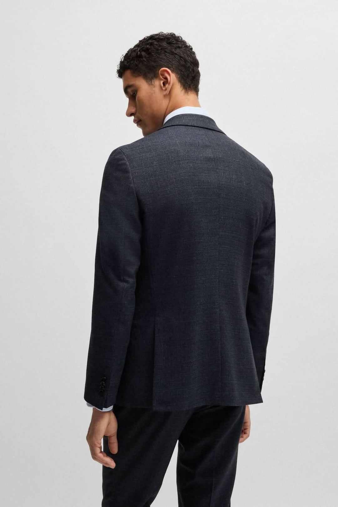 Homme portant un costume deux pièces moderne BOSS avec une coupe ajustée, vu de dos.