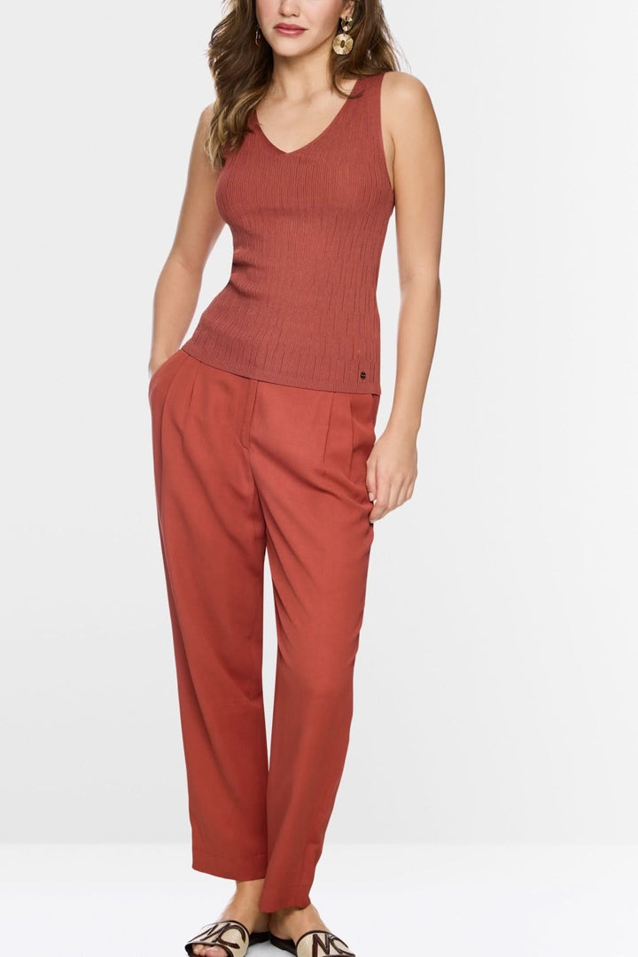 Femme portant haut en maille côtelée sans manches à col v, coupe ajustée, couleur terracotta.
