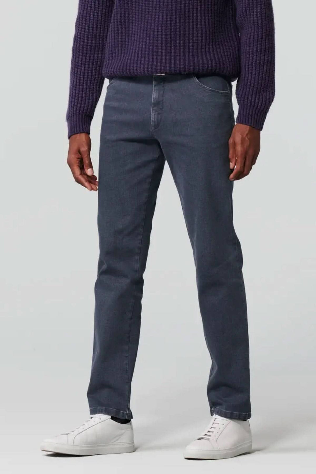Jean slim en denim biologique gris, offrant confort et liberté de mouvement, associé à un pull violet.