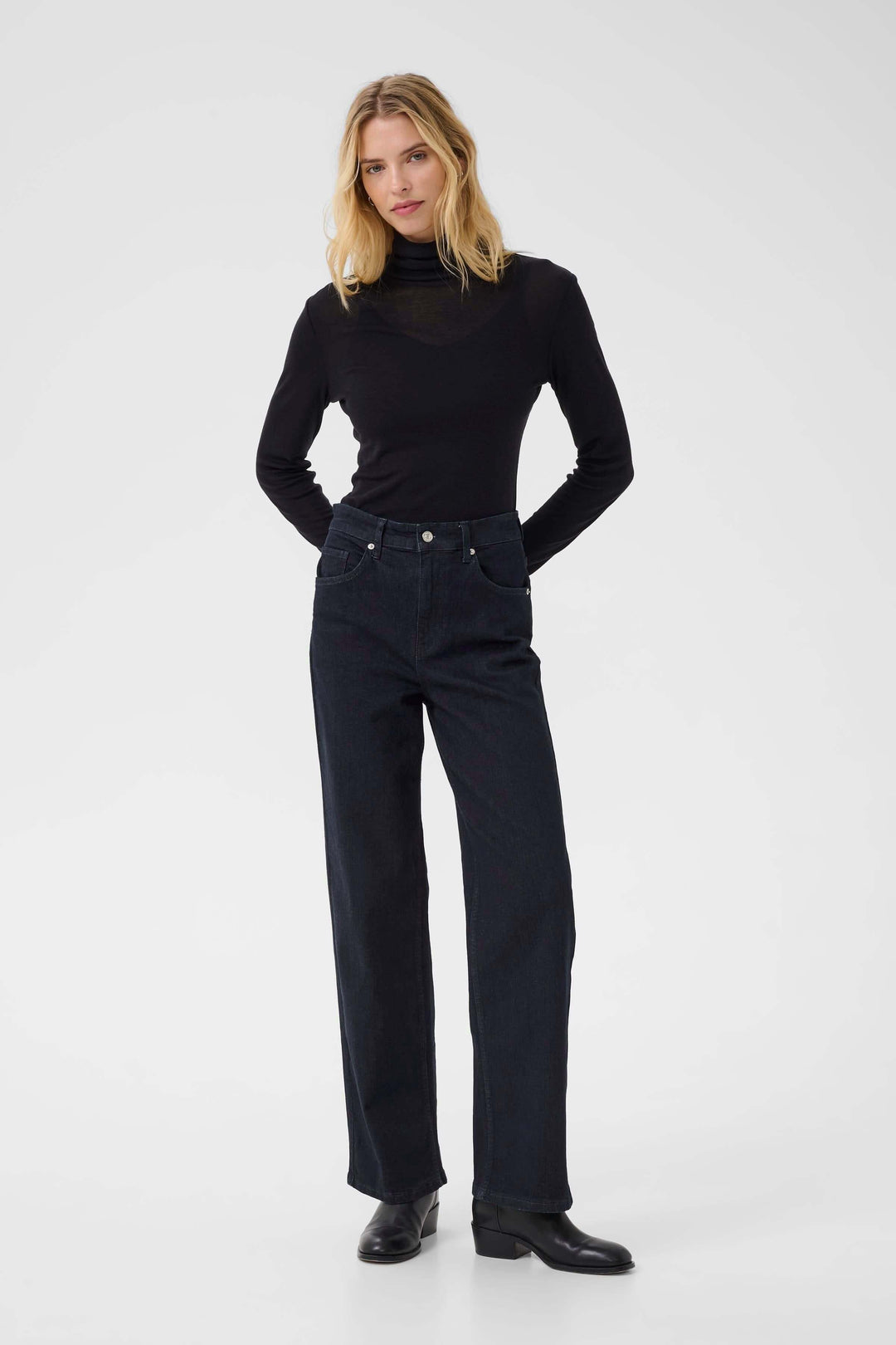 Jean Simona à jambe droite avec taille mi-haute, porté avec un chandail noir. Confort et modernité pour un style polyvalent.