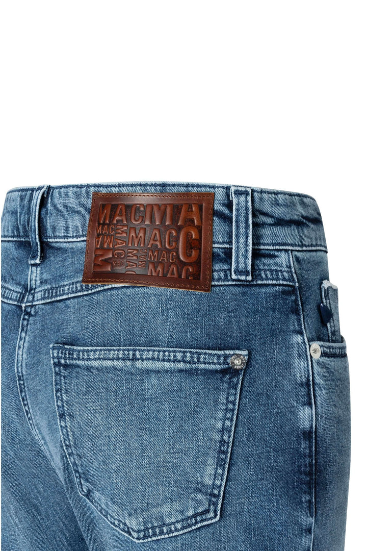 Jean droit avec coupe classique, délavage subtil, et étiquette en cuir marron, tendance et polyvalent pour toutes les garde-robes.