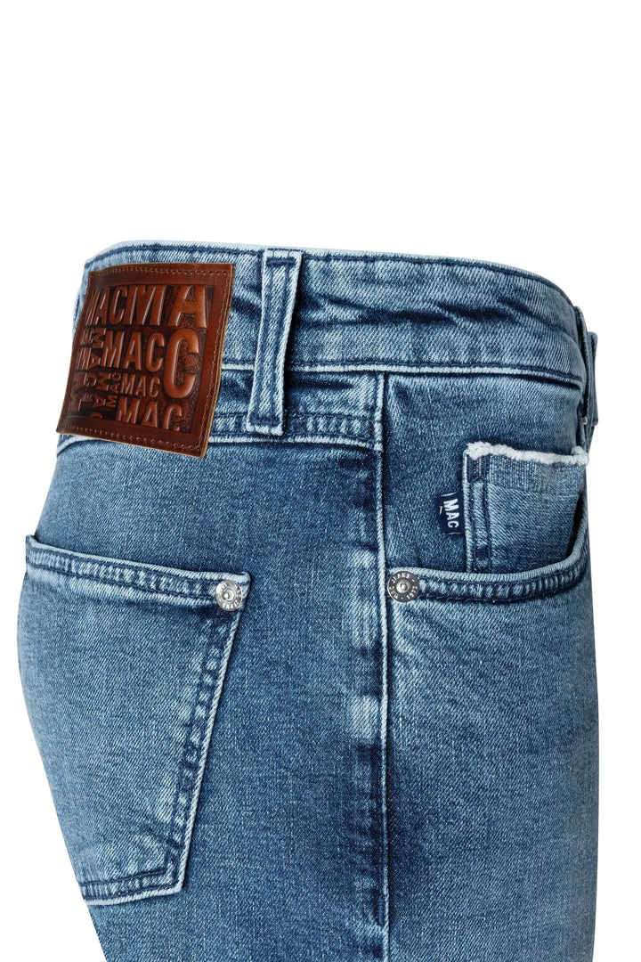 Jean droit bleu délavé avec détails de coutures et étiquette en cuir brun.