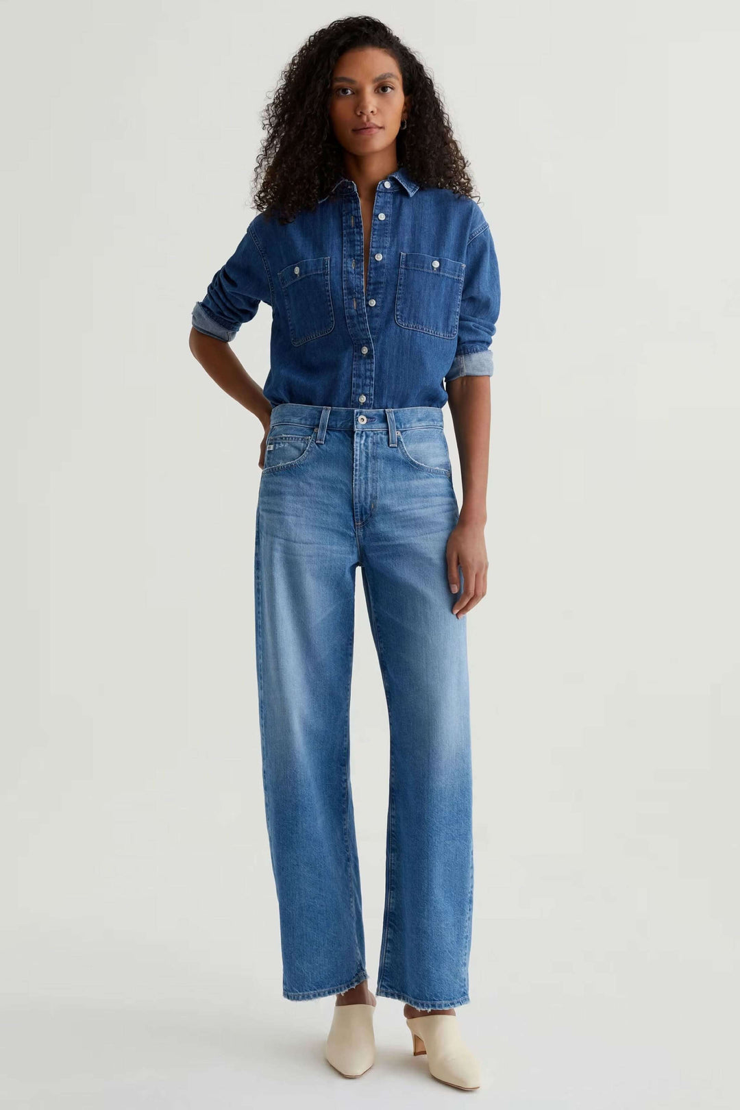 Jean droit à jambe large porté avec une chemise en denim pour un look moderne et décontracté.