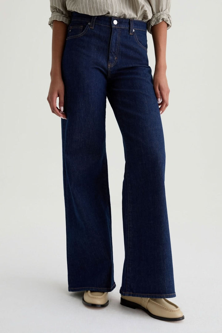 Jean à jambe large en denim avec coupe taille haute et jambe fluide, parfait pour un look moderne et élégant.