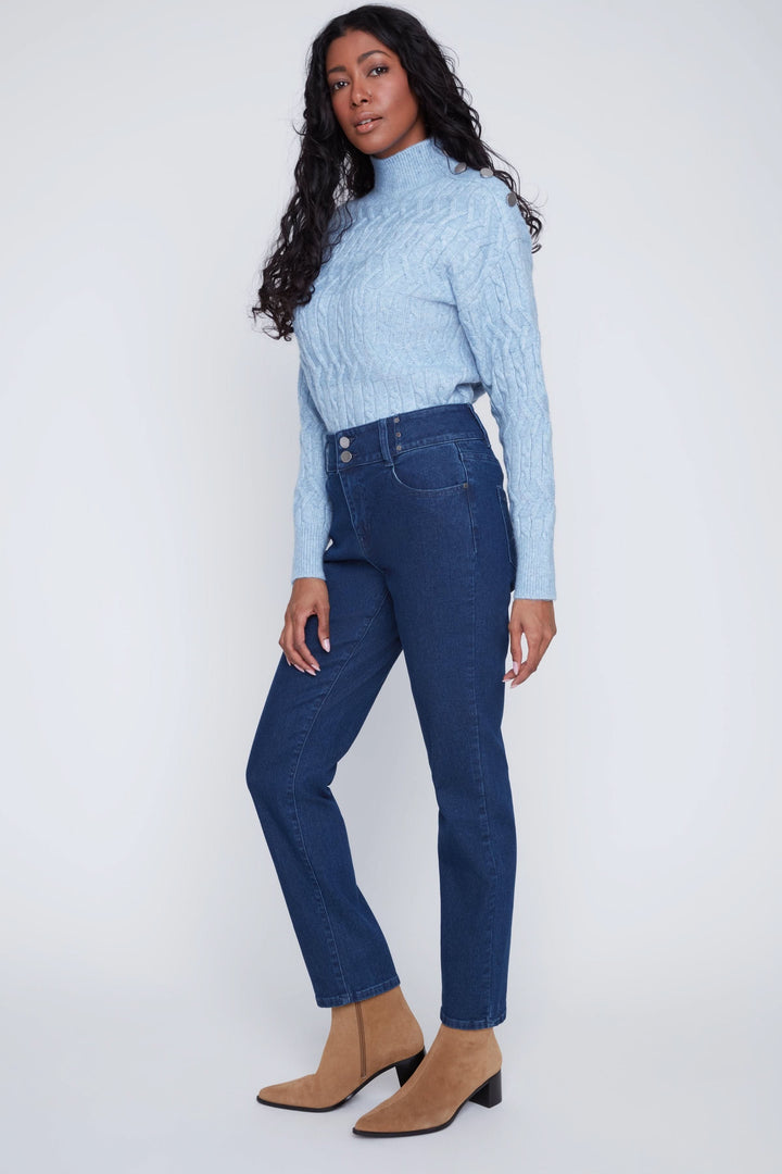 Jean taille haute en denim bleu avec boutons apparents porté par un mannequin avec un chandail bleu, style droit classique.