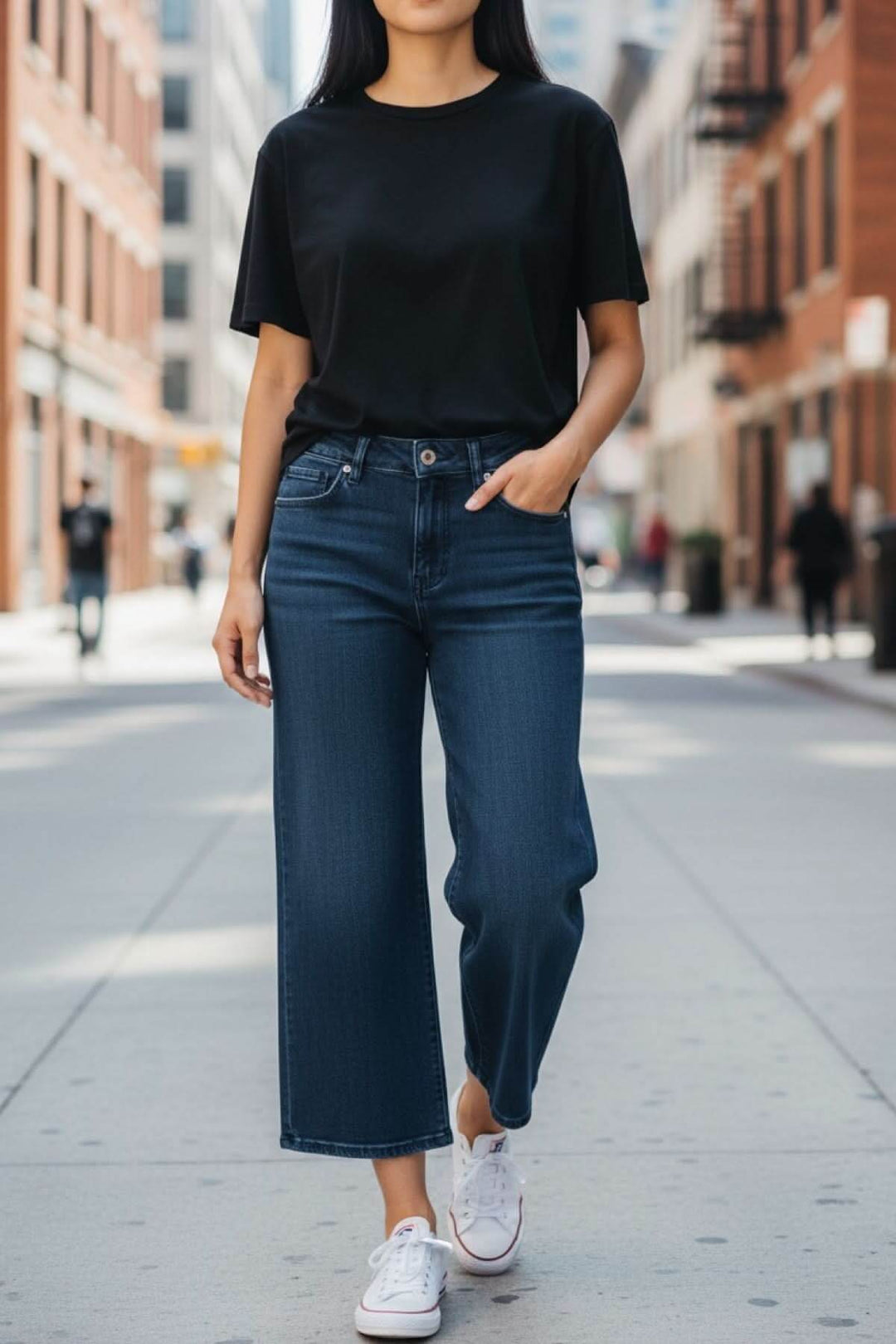 Jeans jambe évasée en denim bleu, style décontracté avec taille régulière, porté avec un t-shirt noir, idéal pour un look moderne.