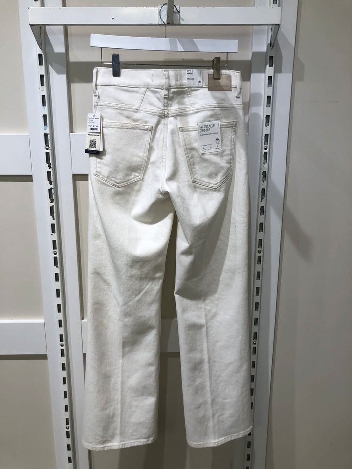 Jeans palazzo blanc MAINE, taille haute, coupe évasée, affichés sur un porte-vêtements en magasin.