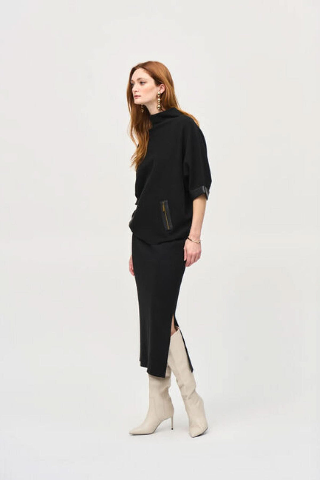 Femme en jupe crayon noire avec un pull, portant des bottes blanches, style élégant avec une coupe moderne.