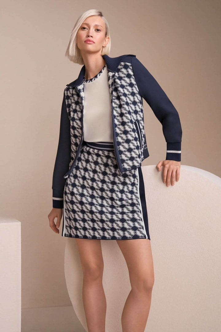 Femme portant une jupe en maille à motif cubique et une veste coordonnée, style contemporain.