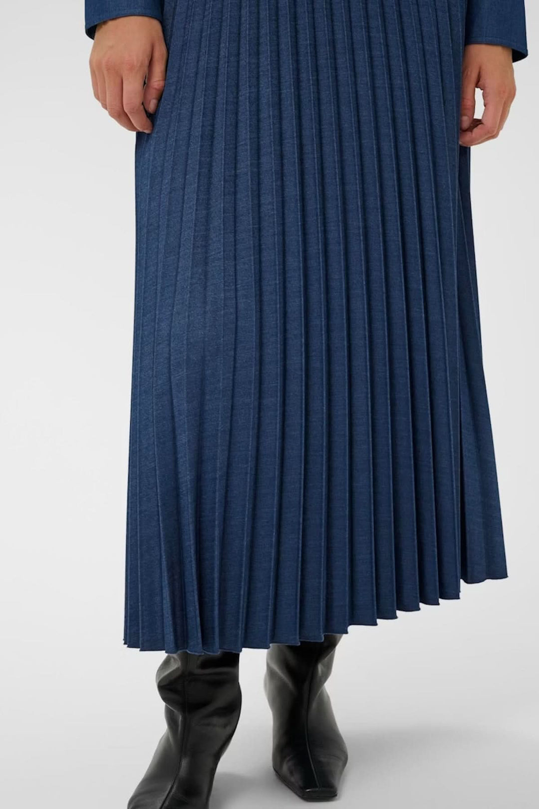 Jupe midi plissée Cherrie en tissu denim, élégante et féminine, mettant en valeur une silhouette fluide idéale pour toute occasion.