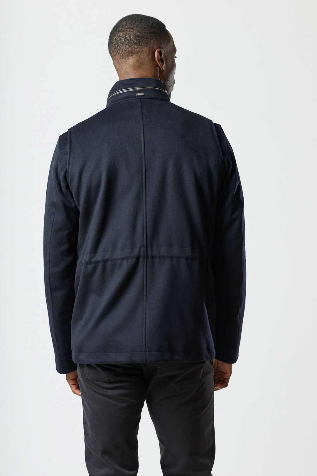 Homme portant un manteau en laine à quatre poches, vue de dos, style smart-casual avec fermeture zippée-boutonnée et col montant.