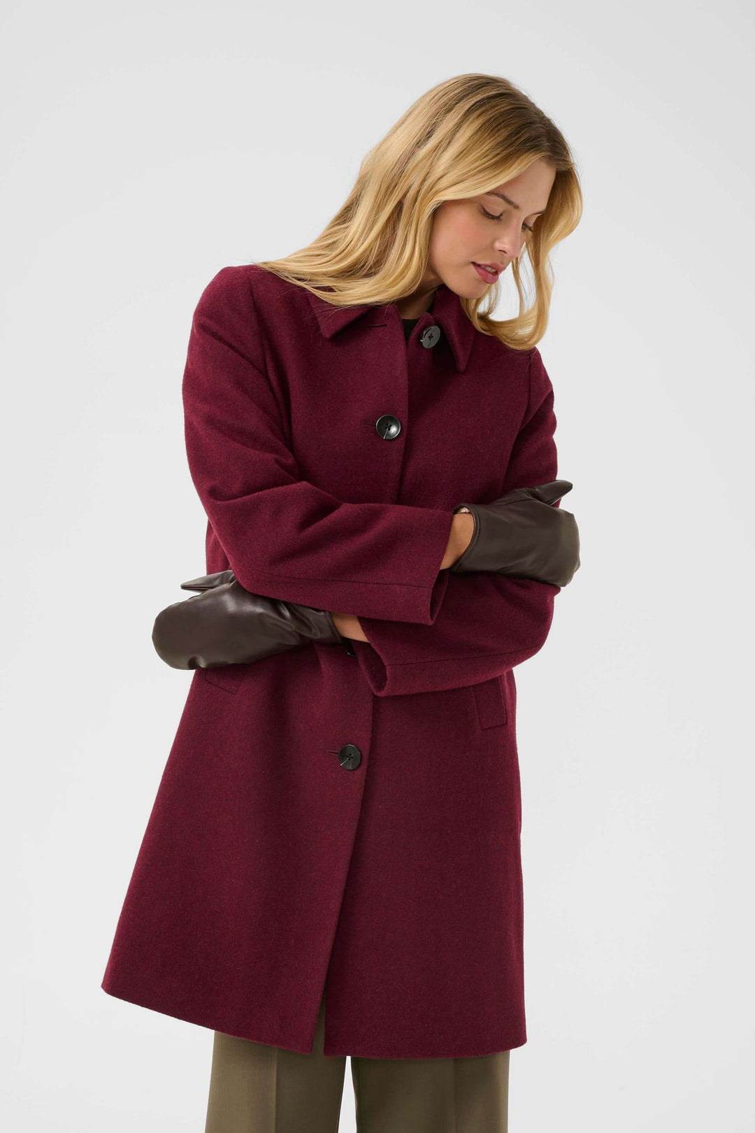 Femme portant un manteau en laine bordeaux et les Mitaines Fiori en cuir, montrant élégance et chaleur pour l&