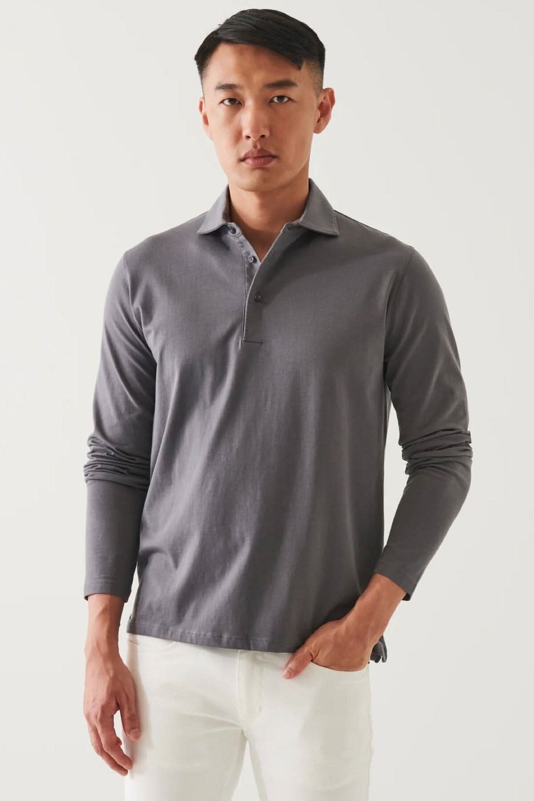 Homme portant un polo en coton stretch à manches longues de couleur gris, avec un ajustement décontracté.