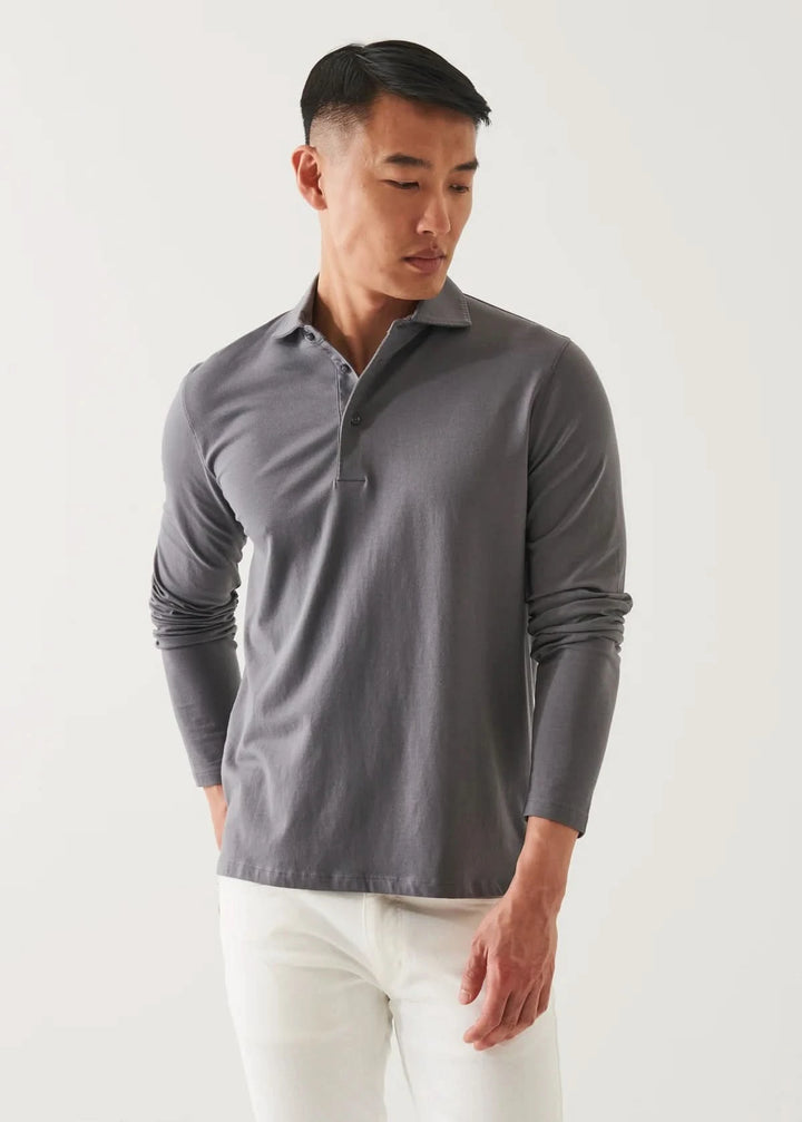 Homme portant un polo de coton stretch à manches longues en gris avec un col surpiqué.