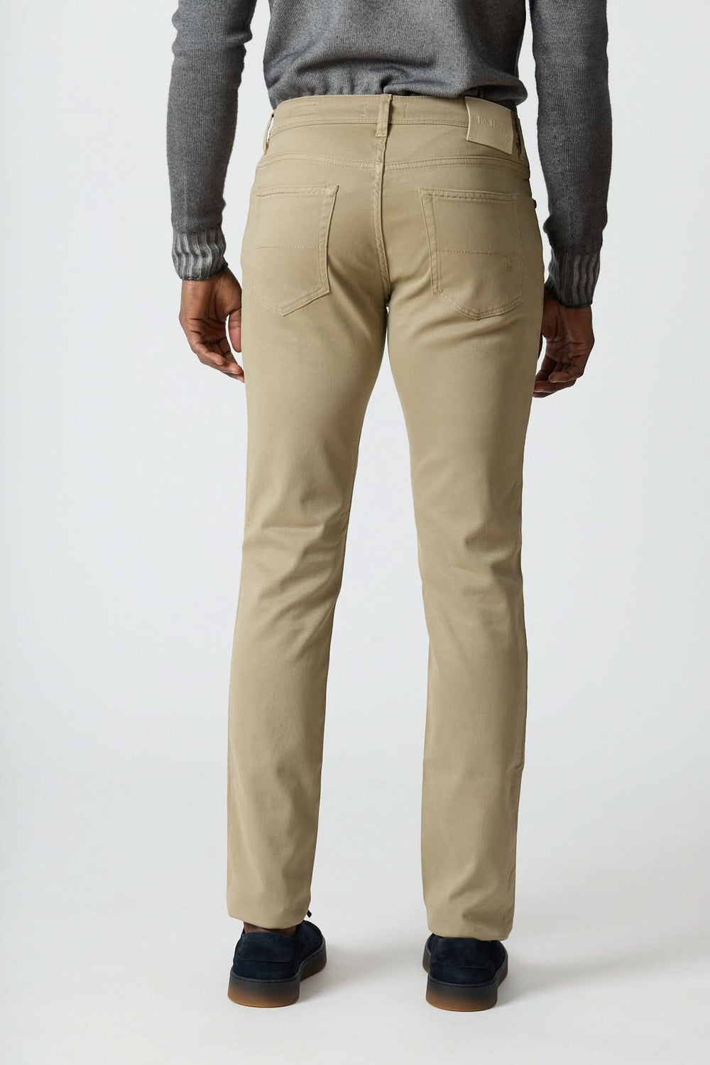 Pantalon 5 poches en sergé coton-lyocell beige, porté de dos, mettant en avant sa coupe ajustée et son élégance italienne décontractée.