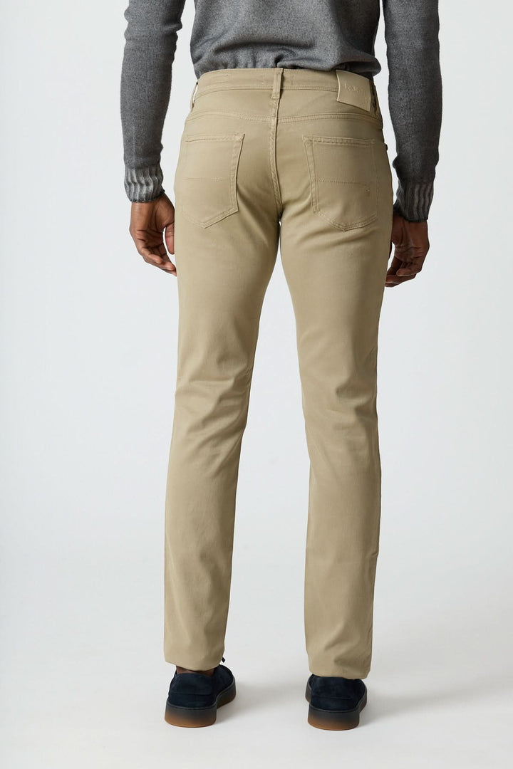 Pantalon 5 poches en sergé coton-lyocell beige, porté de dos, mettant en avant sa coupe ajustée et son élégance italienne décontractée.
