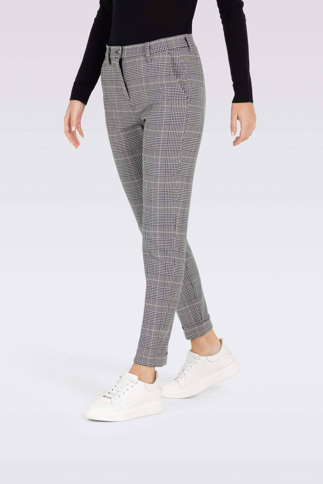 Pantalon chino à carreaux slim coupe confortable avec poches, porté avec des sneakers blanches.