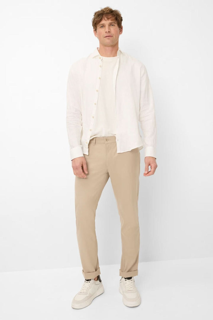 Homme portant le Pantalon Chuck beige, coupe droite moderne et élégante, parfait pour un style décontracté ou habillé.