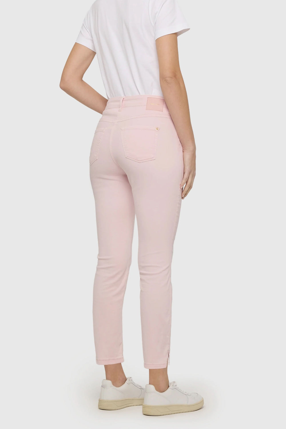 Pantalon Dream Summer rose pâle, coupe ajustée, longueur cheville, porté avec un t-shirt blanc et des baskets blanches.