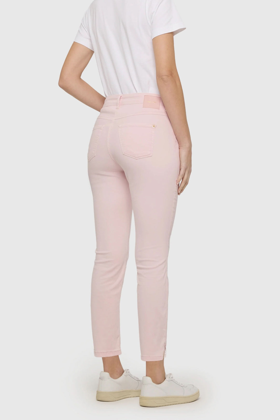 Pantalon Dream Summer rose pâle, coupe ajustée, longueur cheville, porté avec un t-shirt blanc et des baskets blanches.