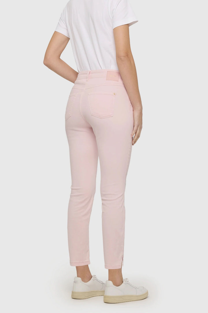 Pantalon Dream Summer rose pâle, coupe ajustée, longueur cheville, porté avec un t-shirt blanc et des baskets blanches.