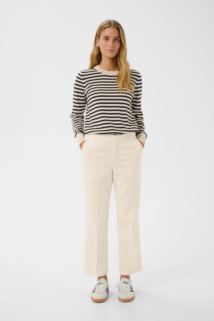 Femmes portant Pantalon Mishas en velours côtelé beige avec chandail rayé, look casual chic avec coupe droite et moderne.
